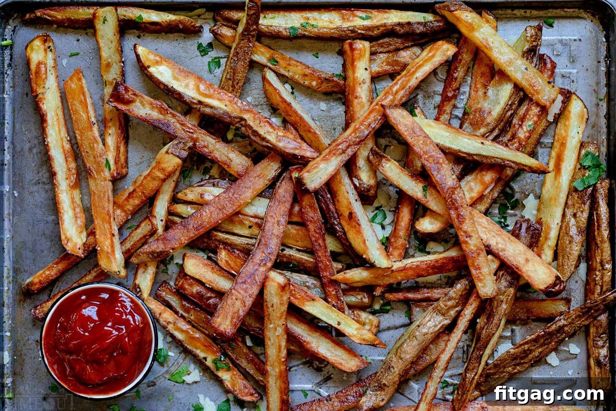 golden fries on baking sheet after being baked in the oven.