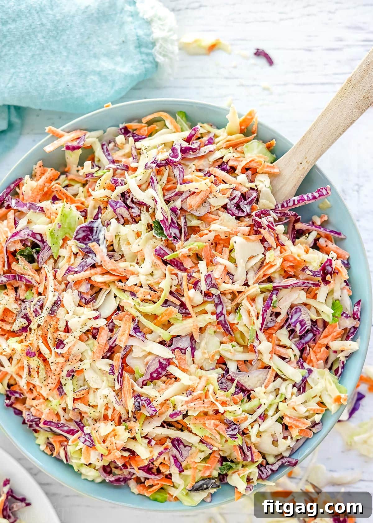Close-up view of tri-colored coleslaw in a light blue bowl, perfectly mixed and ready to be served.