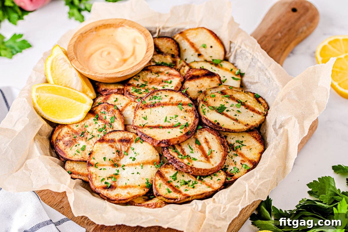 Smoky Garlic Herb Potatoes 4 A rustic wooden serving dish filled with perfectly crispy grilled potato slices, laid over brown parchment paper for an appetizing presentation.