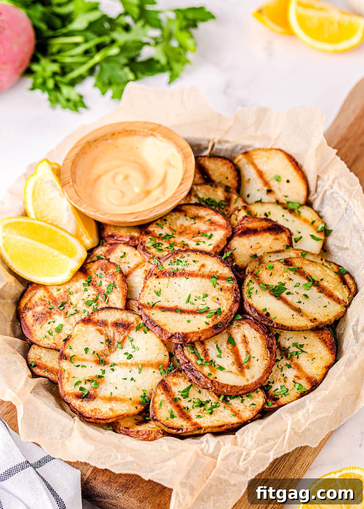 Smoky Garlic Herb Potatoes 7 A large plate presenting easy grilled potatoes, perfectly golden and crispy, accompanied by a side of dipping sauce for a delightful meal.