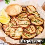 Smoky Garlic Herb Potatoes 8 easy grilled potatoes served with dipping sauce on large plate.