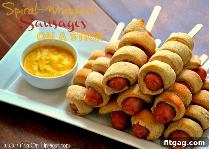 Close-up of Spiral-Wrapped Sausages On a Stick, showcasing the golden dough twisted around the sausage. A perfect kid-friendly snack and easy party food idea.