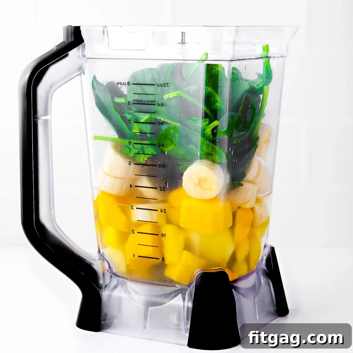The Perfect Green Smoothie 4 A blender filled with a vibrant mix of green smoothie ingredients including spinach, pineapple, mango, and banana, ready to be blended into a healthy drink.