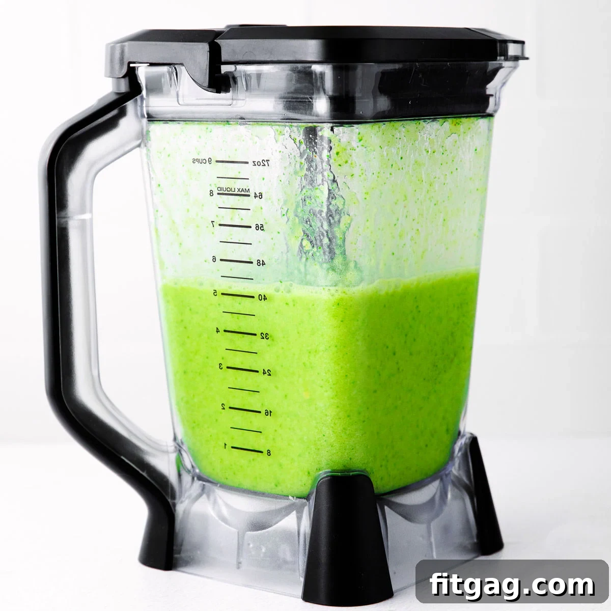 The Perfect Green Smoothie 5 A high-quality blender filled with a perfectly blended, bright green tropical smoothie, showing its smooth and ready-to-serve consistency.
