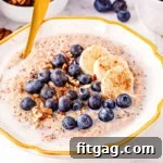 close up look at steel cut oats in bowl topped with blueberries, banana slices and pecans.