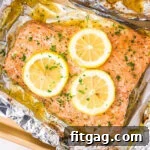 baked salmon in foil topped with lemon slices and fresh parsley.
