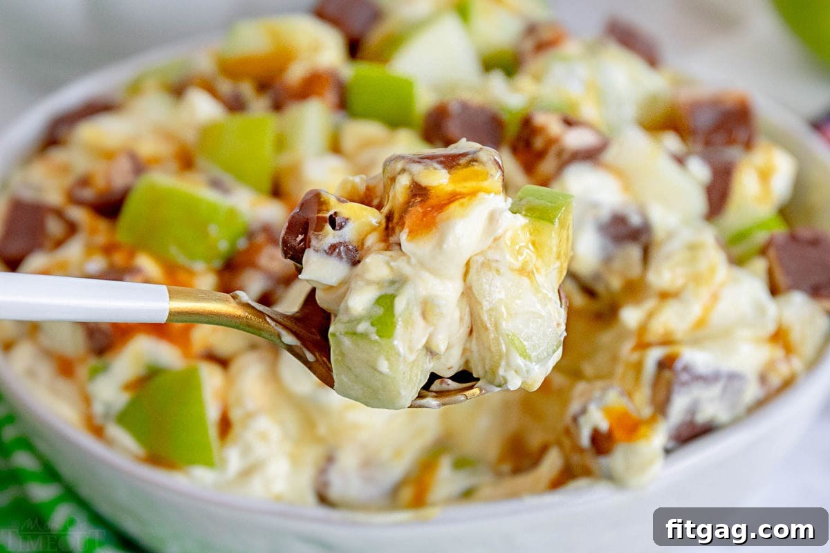 Snickers Caramel Apple Delight 4 spoonful of caramel apple salad held in front of serving bowl.