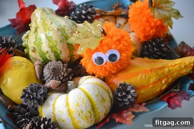 Close-up of a variety of colorful yarn pom poms, ready to be transformed into festive Halloween pumpkins.