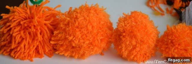 A diverse selection of pom pom pumpkins showcasing various sizes and colors, ready for Halloween decoration.