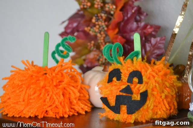 Two finished pom pom pumpkins with different styles: one shabby chic and one jack-o'-lantern with googly eyes and felt mouth. Highlights creative variations.