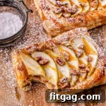 apple tart drizzled with caramel sauce and dusted with powdered sugar on a wood cutting board.