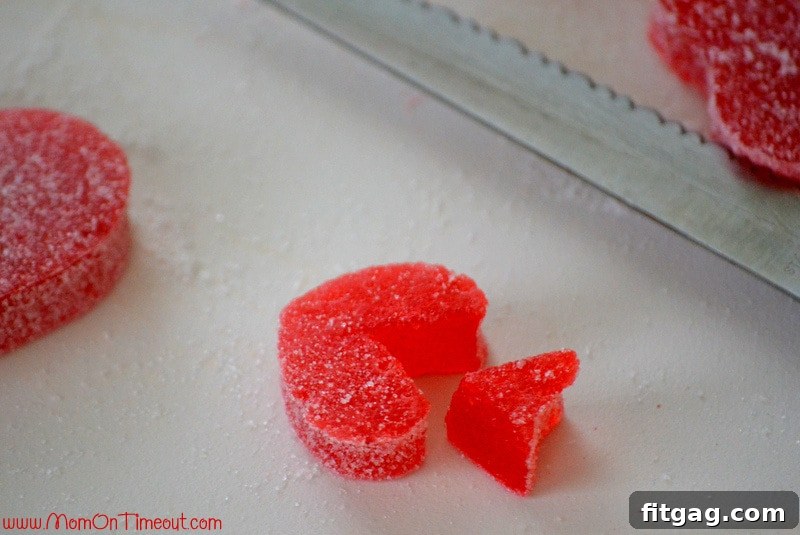 Homemade Gumdrop Love Arrows 2 Demonstration of cutting a V-shape into a gumdrop heart to create the fletching (tail) of a Cupid's Arrow craft.