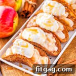 5 apple pie tacos on shallow white serving dish sitting next to blue and white striped napkin and fresh red apples.