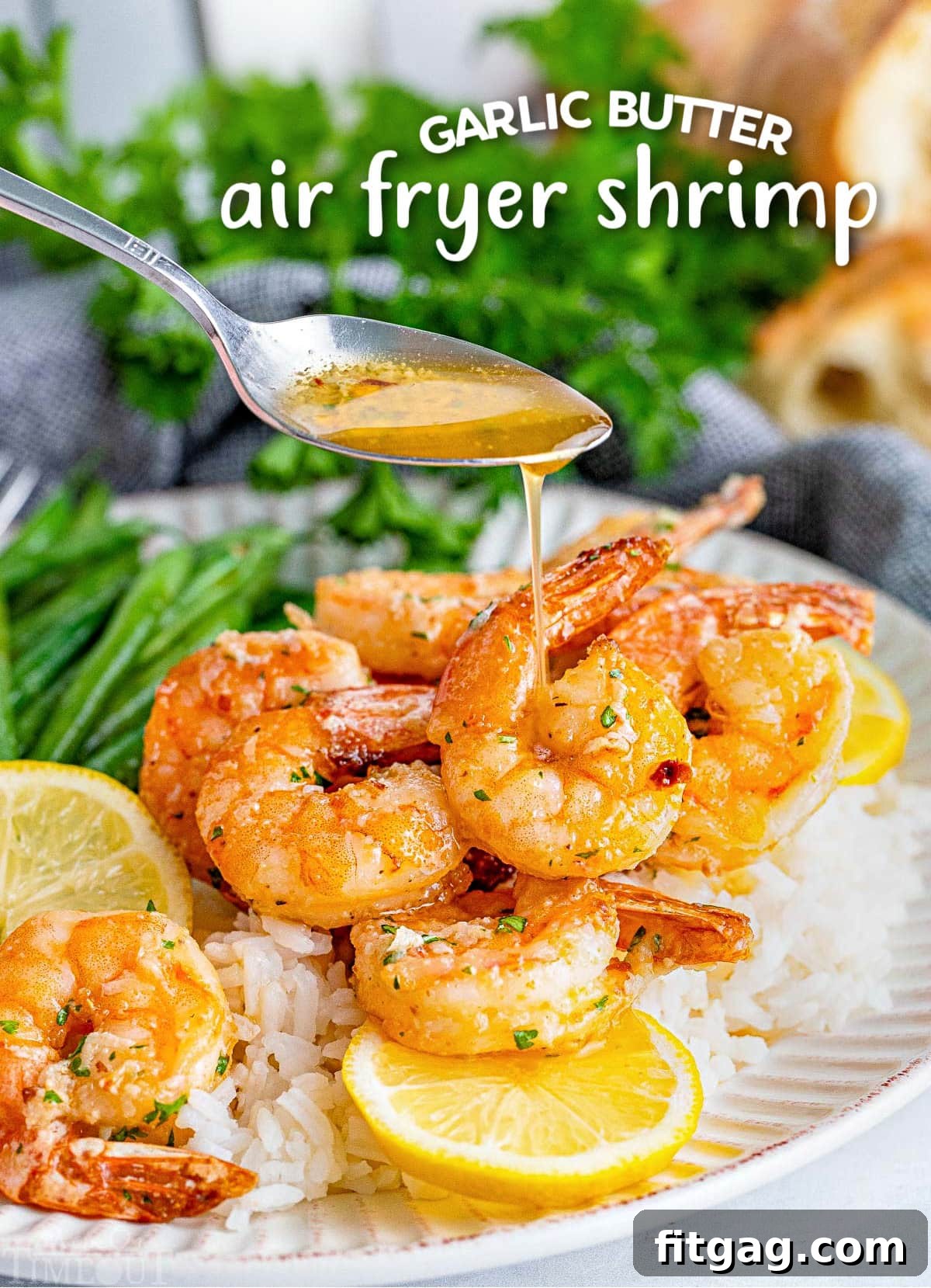Effortless Air Fryer Shrimp 2 Platter of golden air fryer shrimp generously drizzled with garlic herb butter, accompanied by vibrant green beans and fresh lemon slices.