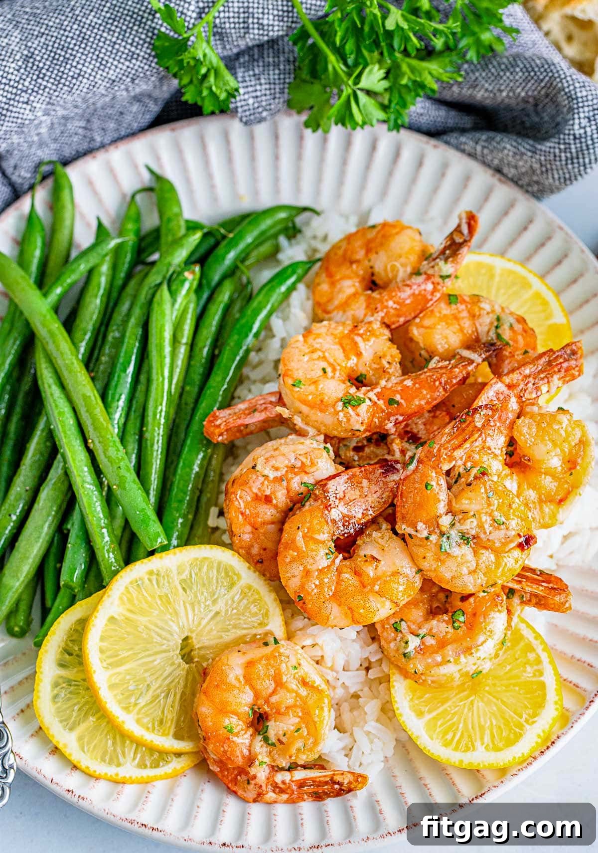 Effortless Air Fryer Shrimp 5 Close-up shot of an abundant plate of air fryer shrimp, golden and perfectly cooked, generously topped with a rich garlic herb butter sauce.