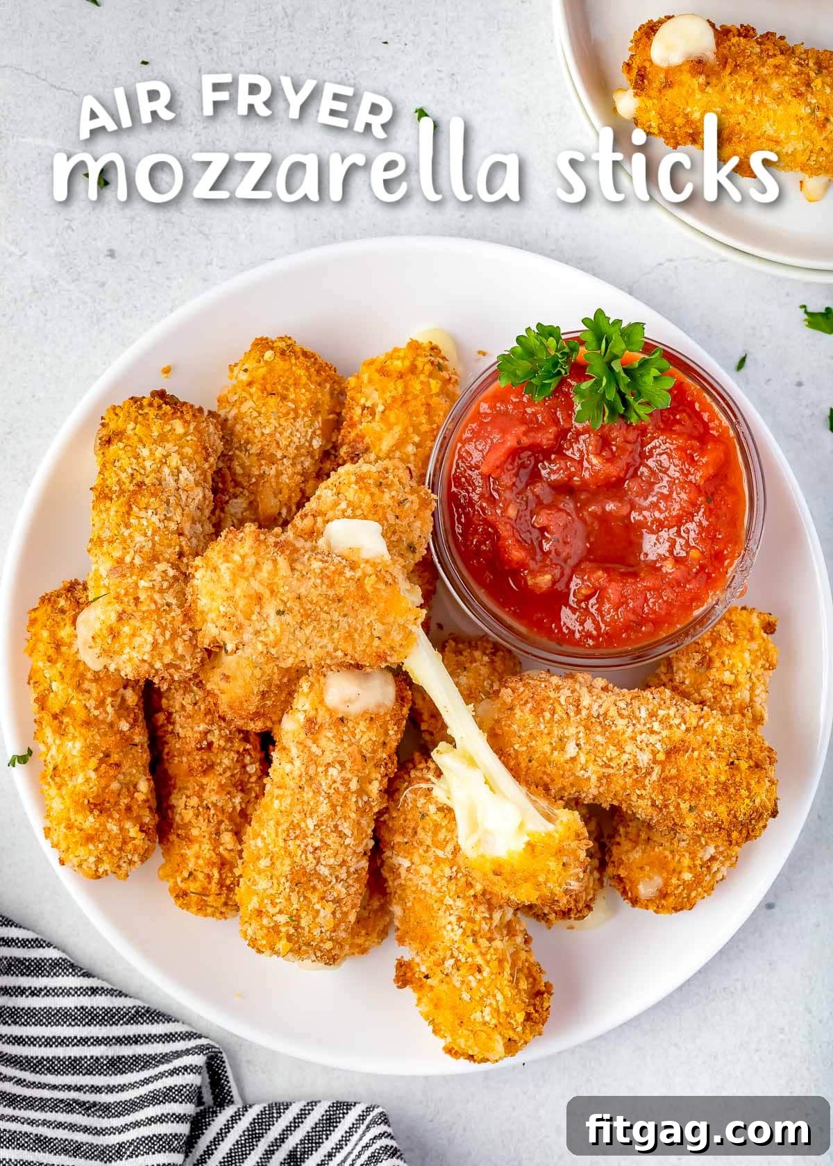 Golden Gooey Air Fryer Mozzarella Sticks 2 A generous pile of perfectly golden and crispy air fryer mozzarella sticks arranged on a white plate, served alongside a small bowl of vibrant marinara sauce. The top of the image features a title overlay.