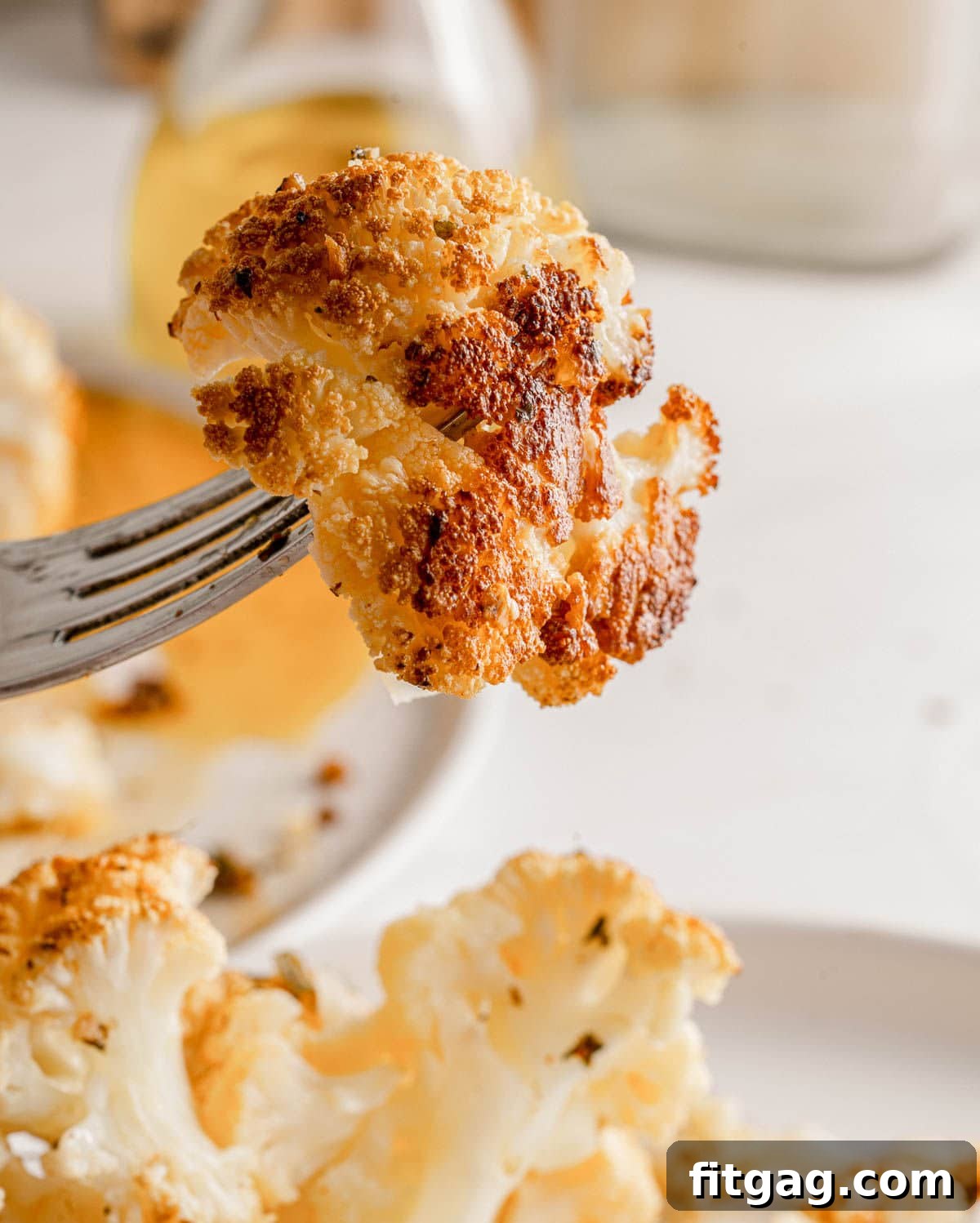 Golden Roasted Cauliflower 3 A perfectly roasted piece of cauliflower, tender and golden brown, held up gracefully on a fork, ready to be enjoyed.