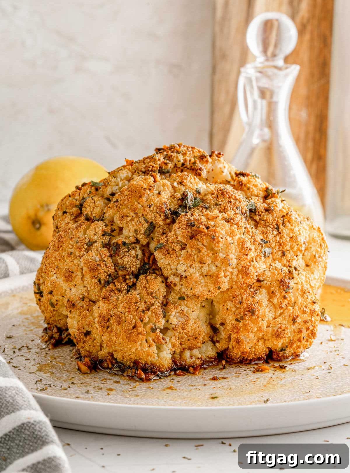 Golden Roasted Cauliflower 6 A vibrant whole roasted cauliflower sitting elegantly on a white plate, ready to be enjoyed as a centerpiece or a delightful side.