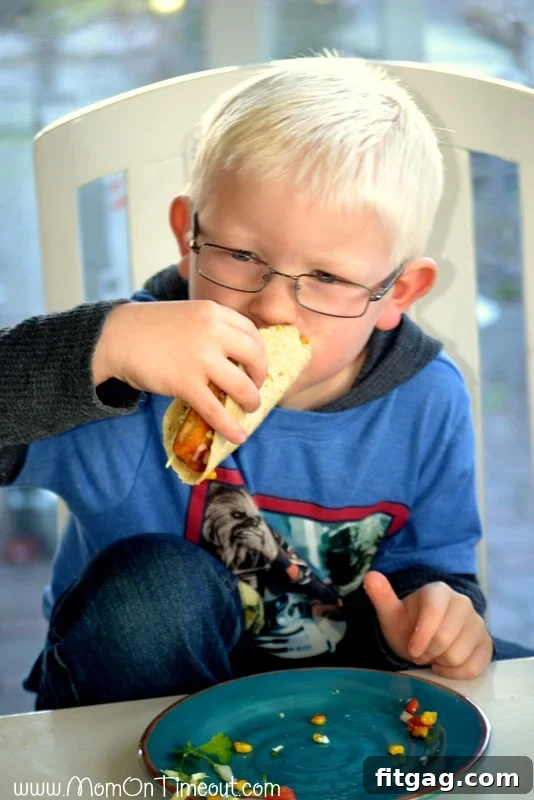 A young boy, Reece, happily eating a fish taco