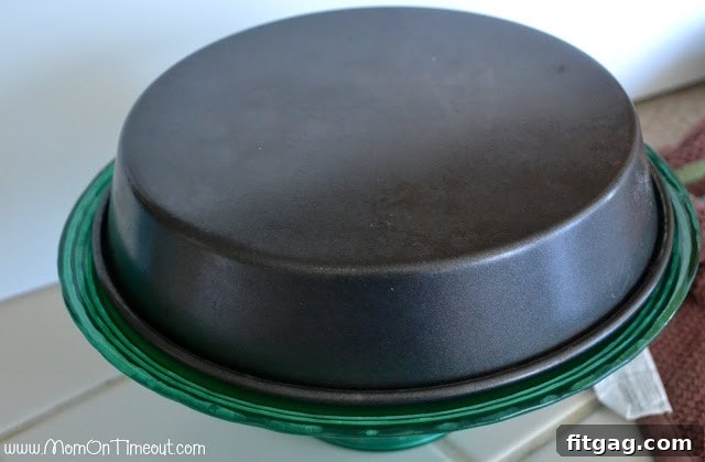A baking pan of sticky buns being inverted onto a serving plate, ready to reveal the caramel topping.