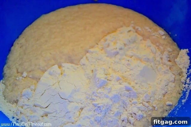 Freshly mixed dough for sticky buns in a stand mixer, smooth and ready for its first rise.