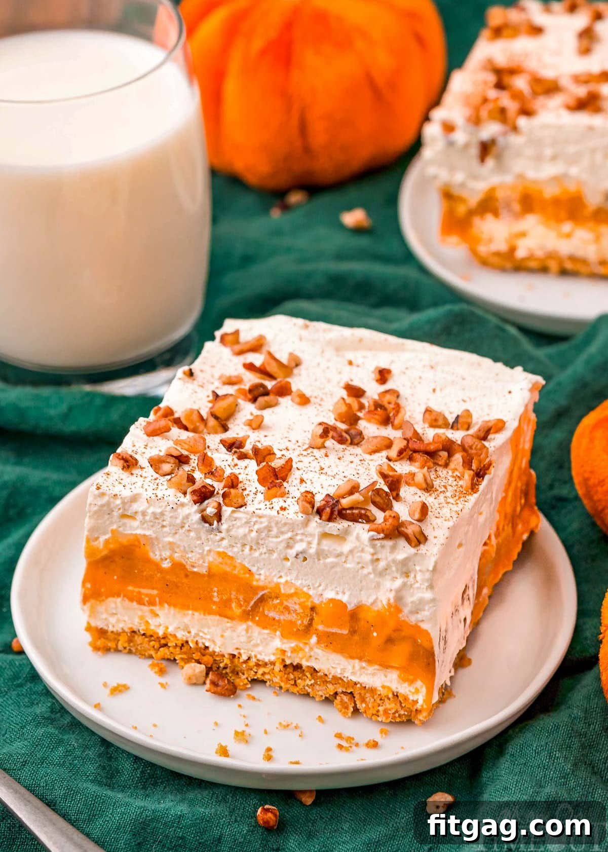 Harvest Pumpkin Bliss 3 Overhead view of a beautiful slice of Pumpkin Delight dessert on a white plate, garnished with toasted pecans and a sprinkle of pumpkin pie spice. A glass of milk is softly blurred in the background, hinting at the perfect pairing.
