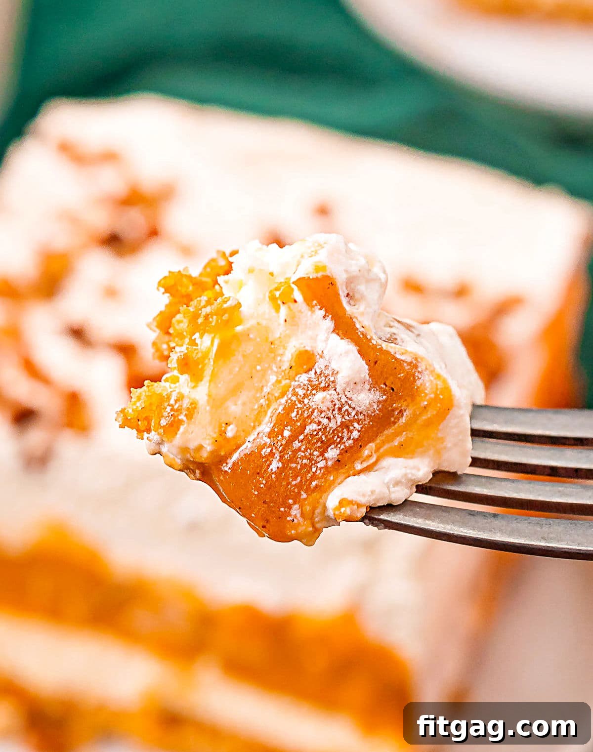 Harvest Pumpkin Bliss 5 A close-up of a fork holding a perfect bite of Pumpkin Delight, showing all four distinct layers, with the rest of the dessert in the baking dish softly blurred in the background, inviting a taste.