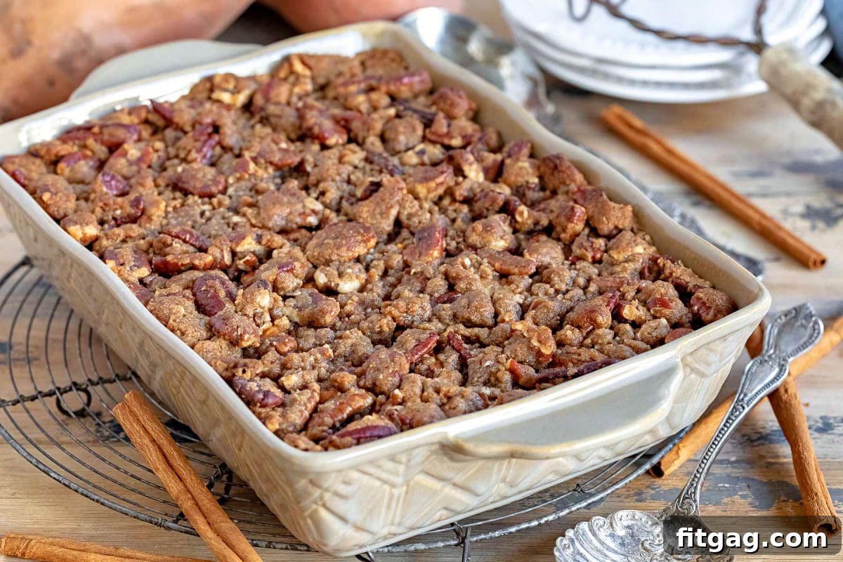 a brown baking dish with a sweet potato casserole in it sitting on a cooling rack.