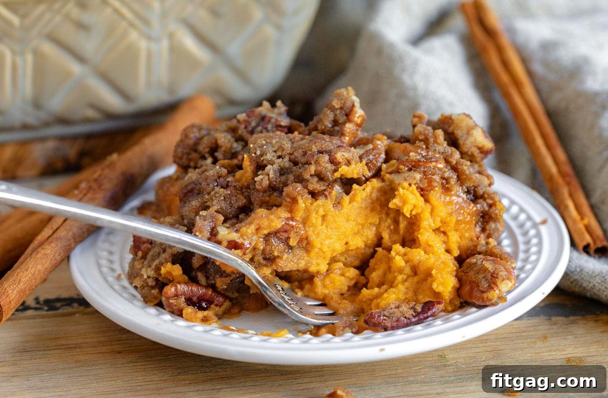 small plate with sweet potato casserole being eaten with a fork.