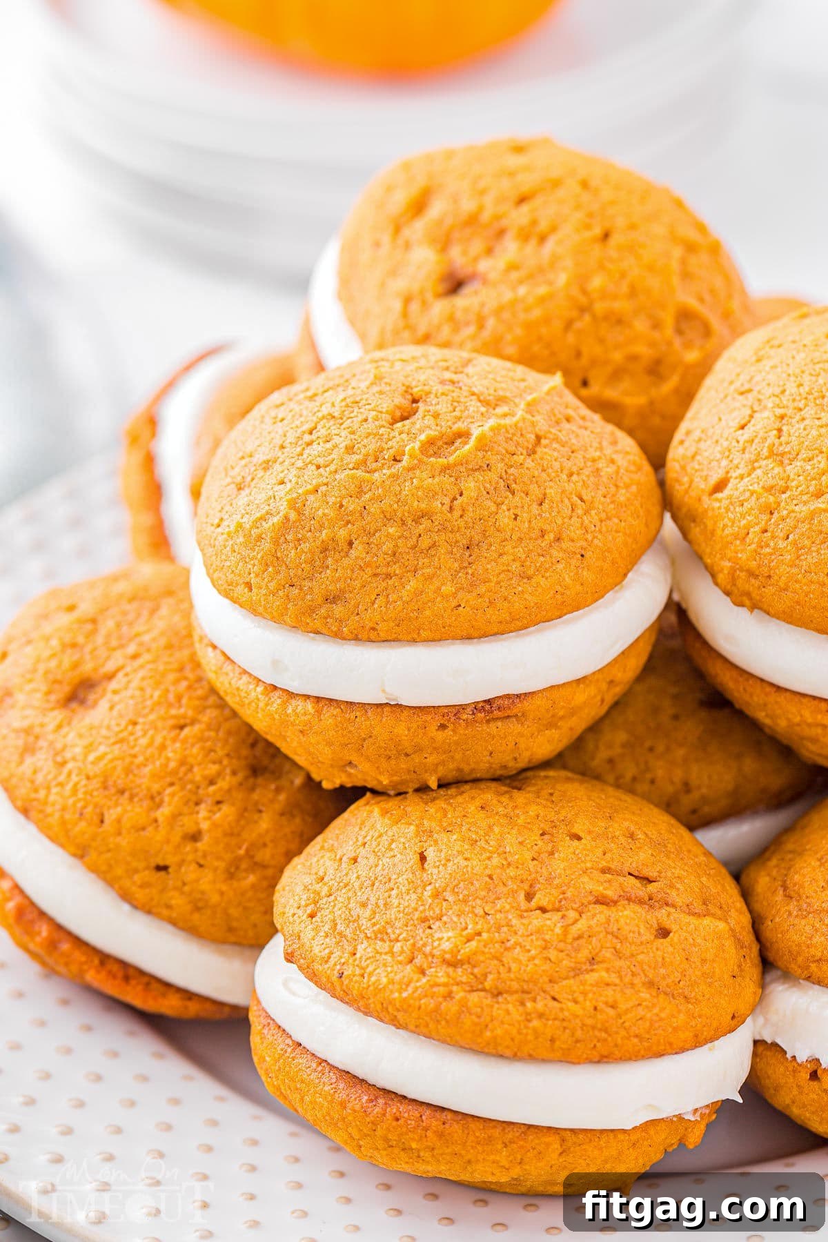 Pillowy Pumpkin Cream Sandwiches 8 a dozen pumpkin whoopie pies on a white plate piled high.