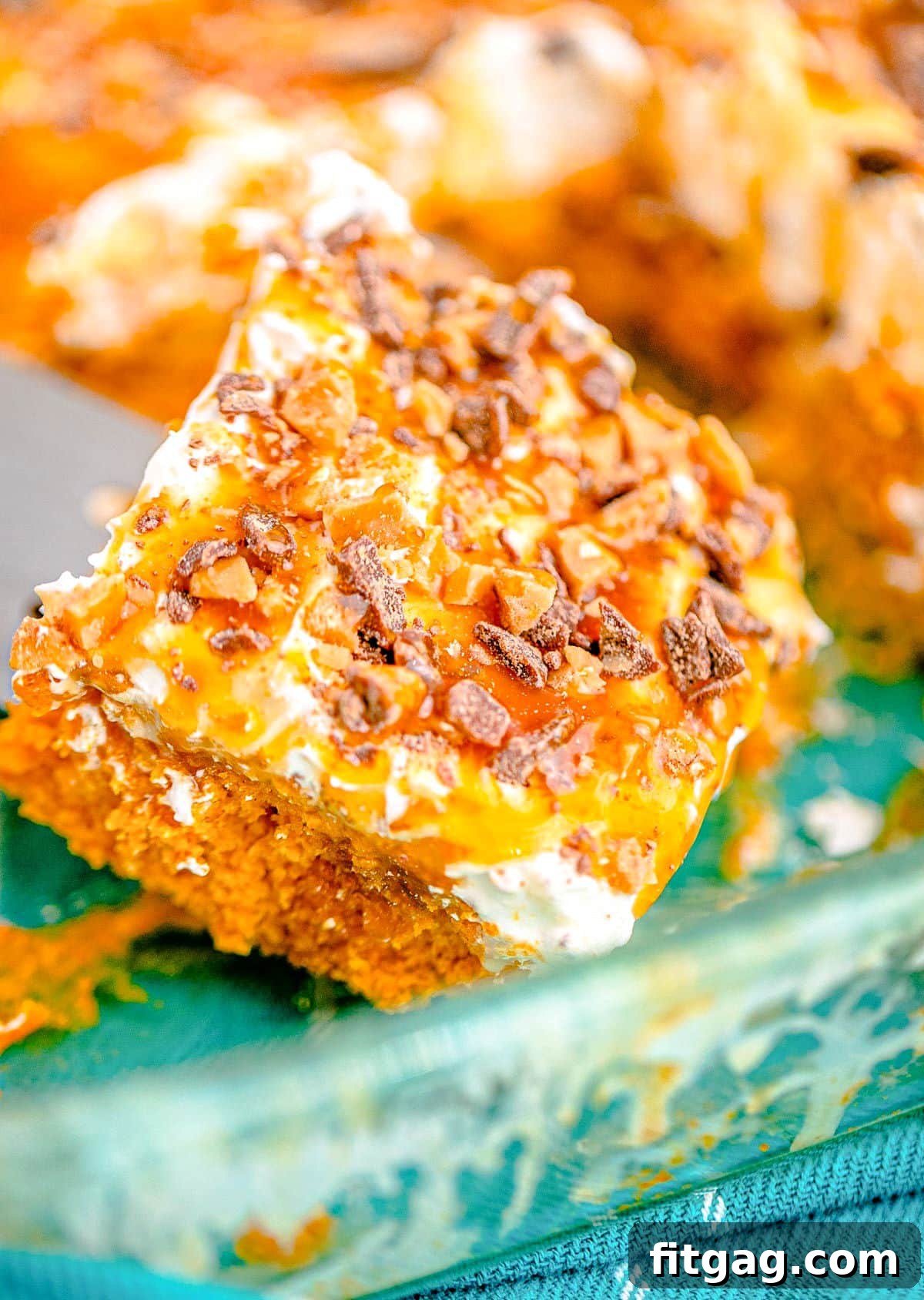 A piece of pumpkin cake is about to be served from a baking dish.