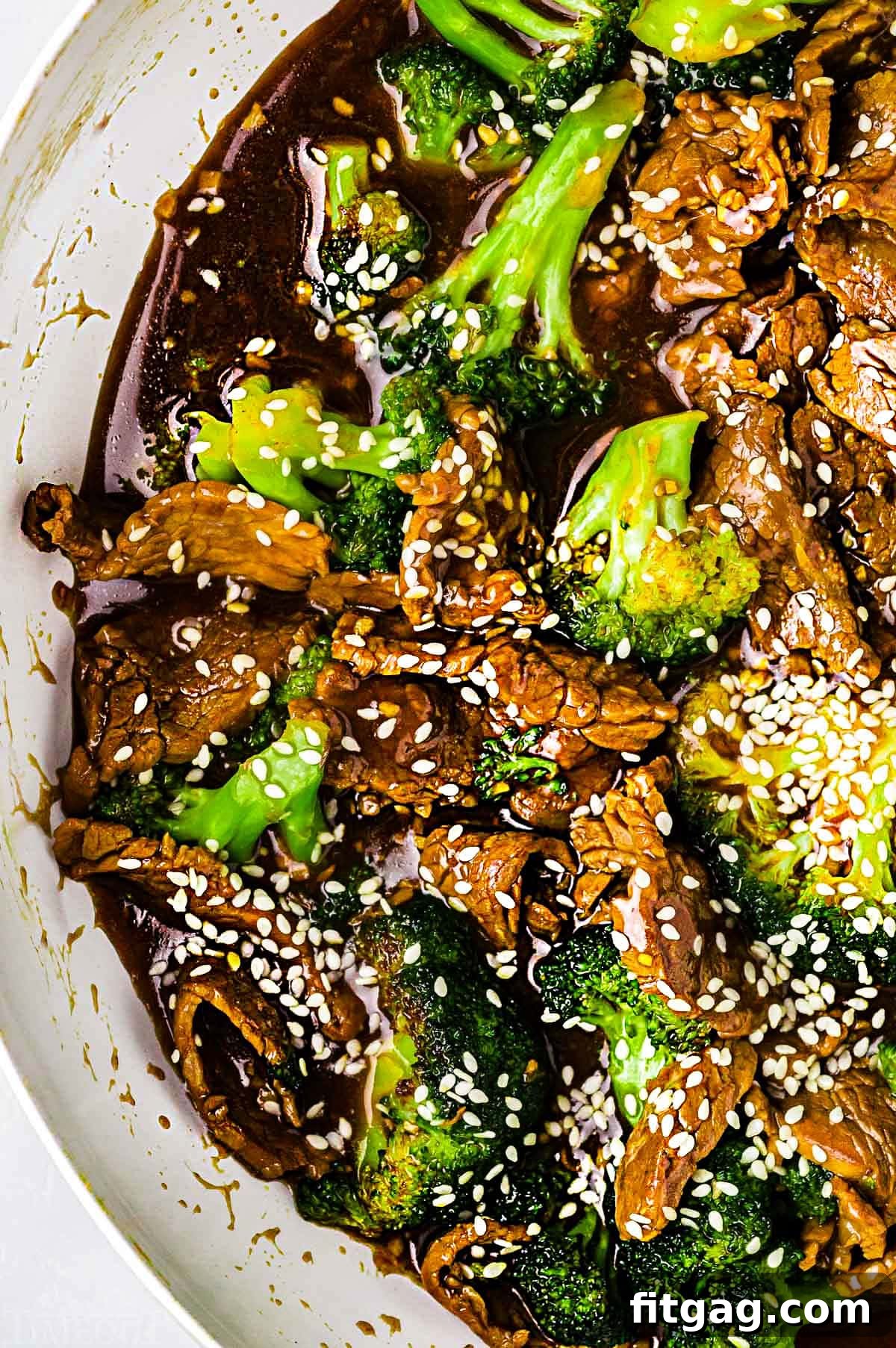 Restaurant-Style Beef and Broccoli Stir-fry 4 A birds-eye view of the delectable Beef and Broccoli stir fry, beautifully arranged in a white skillet, showcasing the harmonious blend of ingredients and inviting textures.
