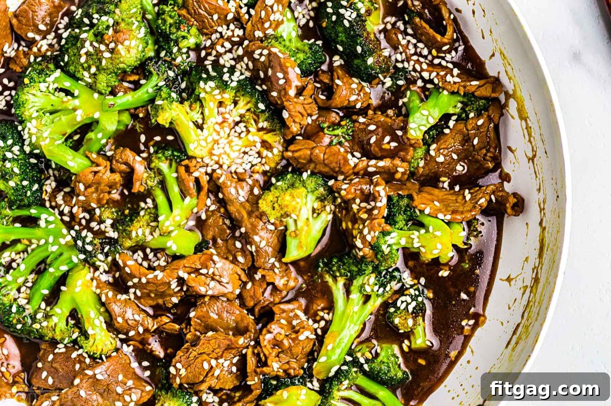 Restaurant-Style Beef and Broccoli Stir-fry 6 A visually appealing top-down view of the Beef and Broccoli stir fry recipe, perfectly cooked and presented in a white skillet, with white sesame seeds sprinkled on top, ready to be served.