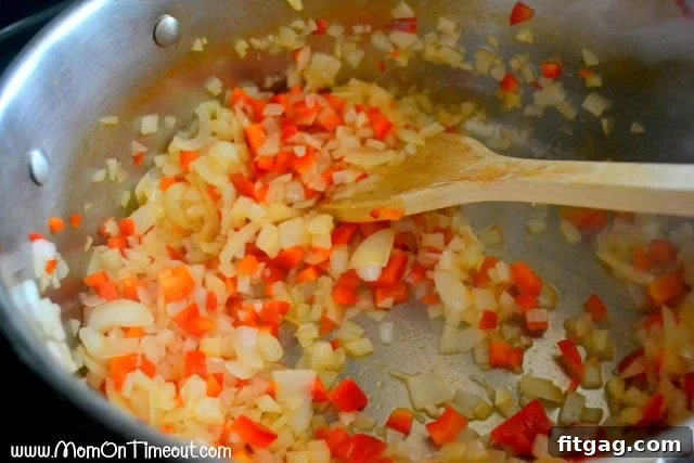 Onions, bell peppers, and garlic sautéing in a large pot, forming the aromatic base for an easy homemade pasta sauce.