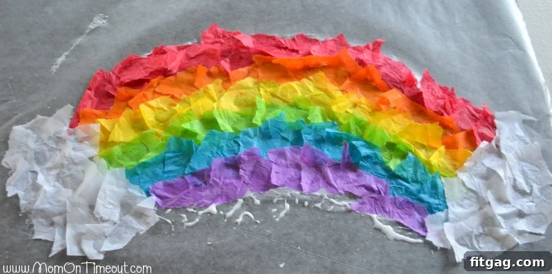 Sparkling Rainbow Suncatchers 6 Partially completed stained glass rainbow craft with torn tissue paper, showing optional white tissue paper clouds at the ends.