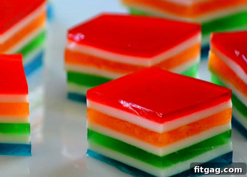 Close-up of freshly cut Rainbow Jello Cubes, showcasing their distinct, colorful layers and appealing texture.