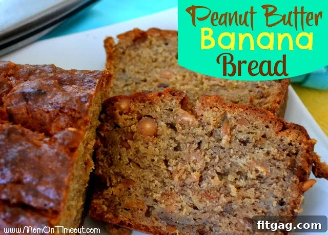 A freshly baked loaf of Peanut Butter Banana Bread on a white plate with two perfect slices cut, showcasing its moist texture and peanut butter chips.