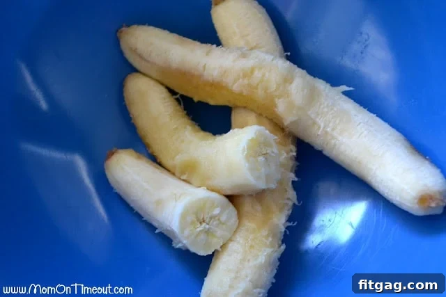 Three perfectly ripe bananas, ready for mashing, in a vibrant blue mixing bowl.