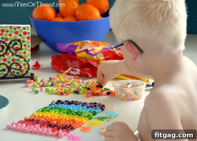 Confetti Sugar Cookie Bark 4 A young boy, Reece, enthusiastically sorting a colorful pile of candies, preparing them for the rainbow cookie bark recipe. A fun activity for kids in the kitchen.