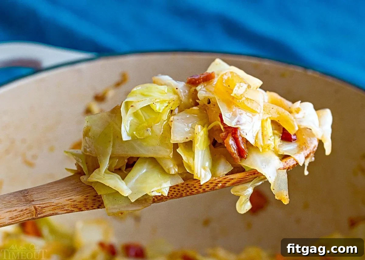 Golden Fried Cabbage 4 A wooden spoon delicately lifts a generous scoop of perfectly fried cabbage from a deep cooking pot. The cabbage, infused with bacon, onion, and garlic, steams gently, promising a comforting and flavorful experience.