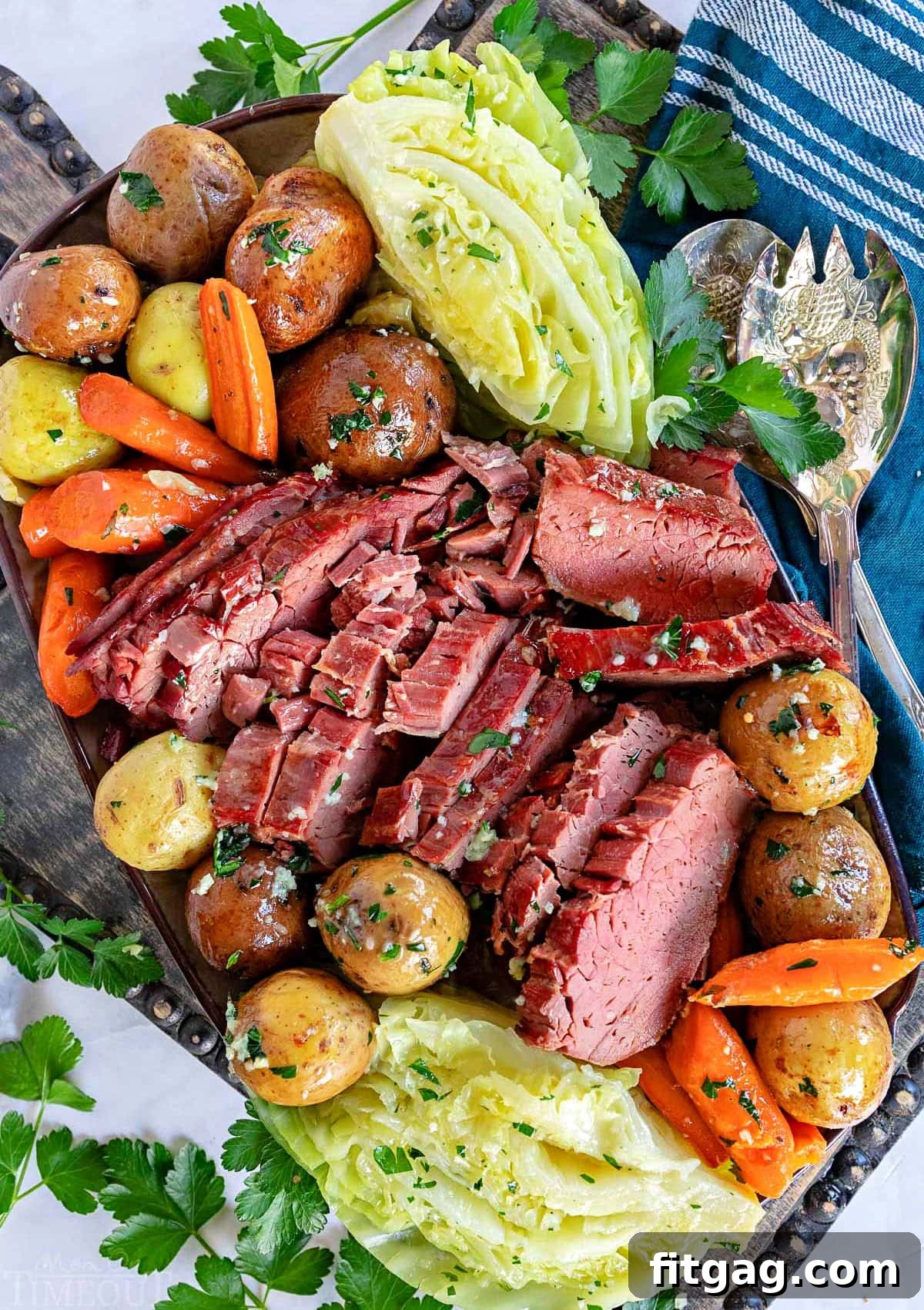 Tender Slow Cooker Corned Beef and Cabbage 2 top down look at crockpot corned beef cut up with cabbage, carrots and potatoes all arranged on a serving platter ready to be served.