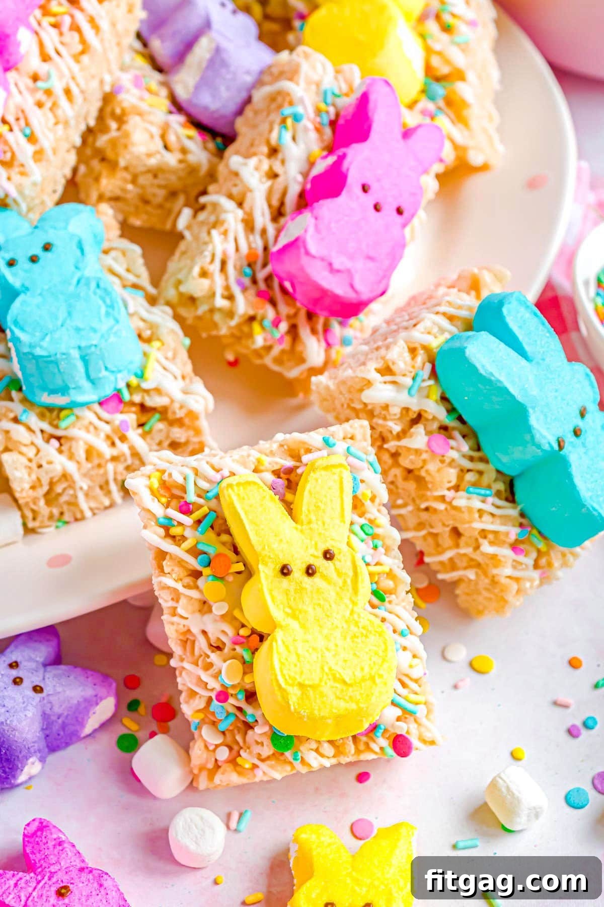 Gooey Peeps Cereal Bars 6 A festive arrangement of decorated Rice Krispie Treats, each topped with a colorful Easter Peep and sprinkles, beautifully displayed on a white plate, ready to be enjoyed.