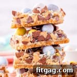 Whimsical Easter Magic Bars 7 magic cookie bars topped with cadbury easter eggs stacked four high on a white surface.