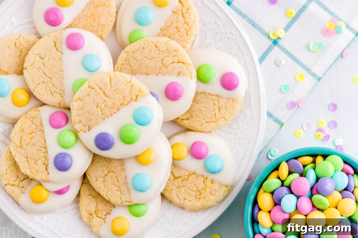 top down look at plate of Easter cake mix cookies decorated with M&Ms sitting on a teal and white napkin and next to a bowl of M&Ms.