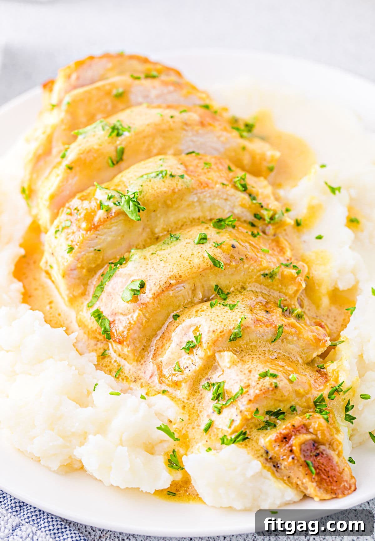 Crispy Honey Mustard Chicken Bites 2 Close-up view of perfectly sliced Honey Mustard Chicken breast served on a bed of creamy mashed potatoes, generously topped with its vibrant, savory sauce.