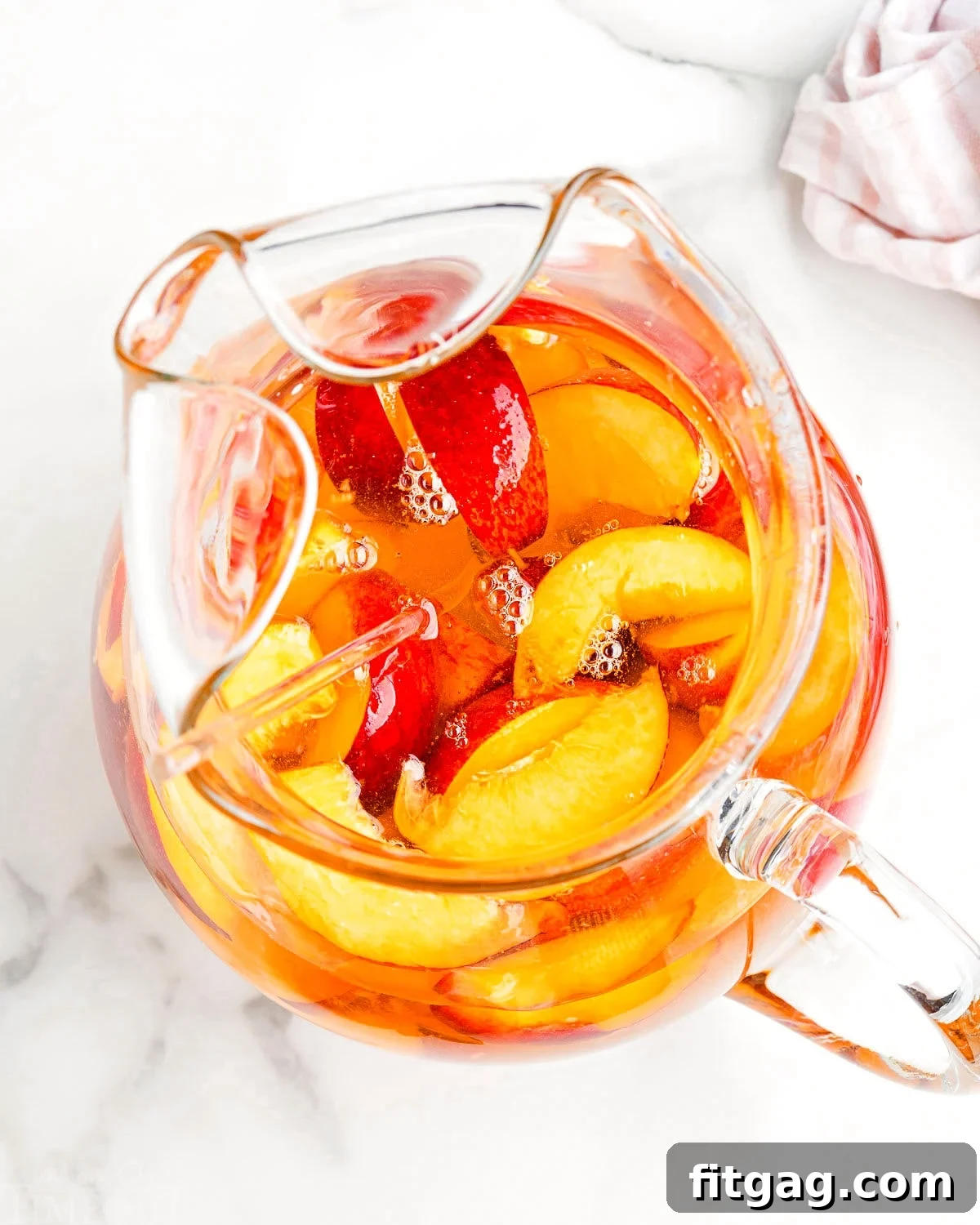 Golden Peach Sangria 3 pitcher of white sangria flavored with peaches and peach liquor.