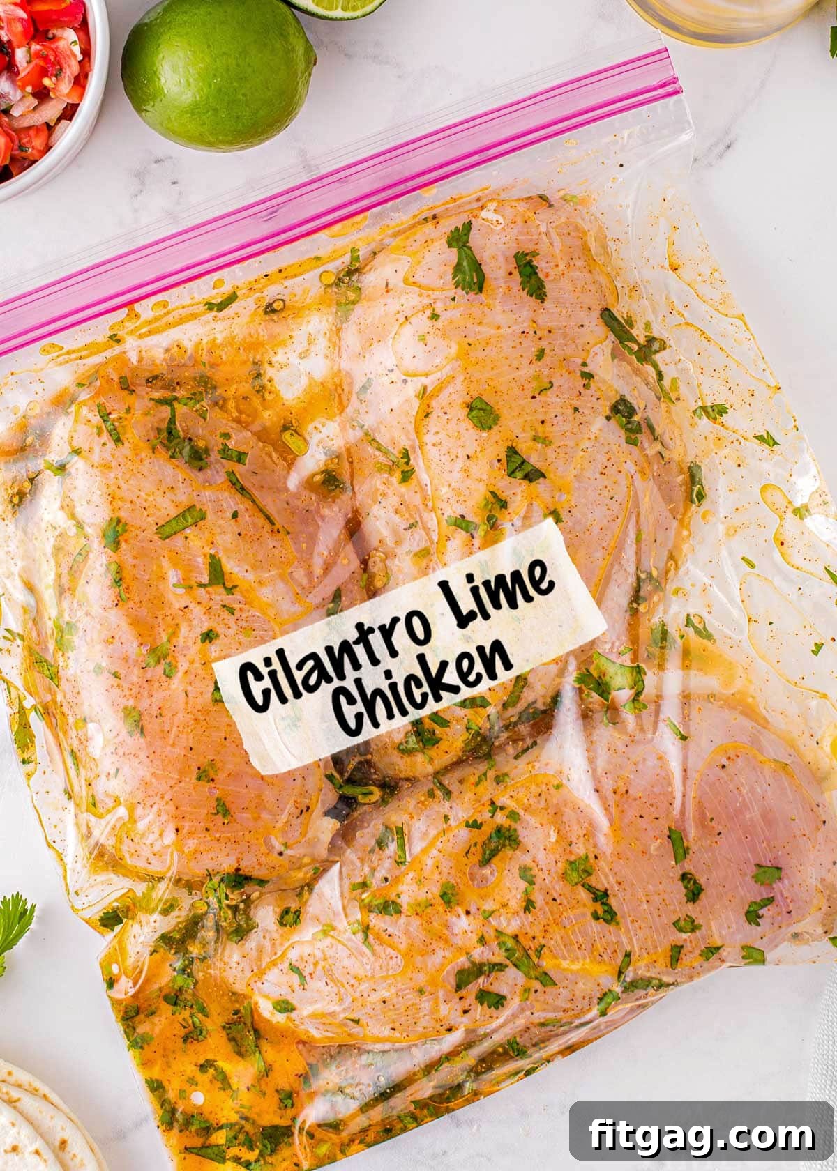 three chicken breasts in a cilantro lime marinade in a ziploc bag with a cilantro lime chicken label on the front.