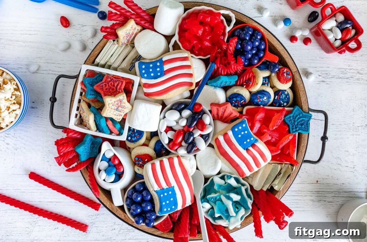 Stars and Stripes Grazing Board 7 A top-down perspective of a wooden charcuterie board, richly laden with an array of red, white, and blue desserts, including cookies, candies, and various colorful treats, perfect for the 4th of July.