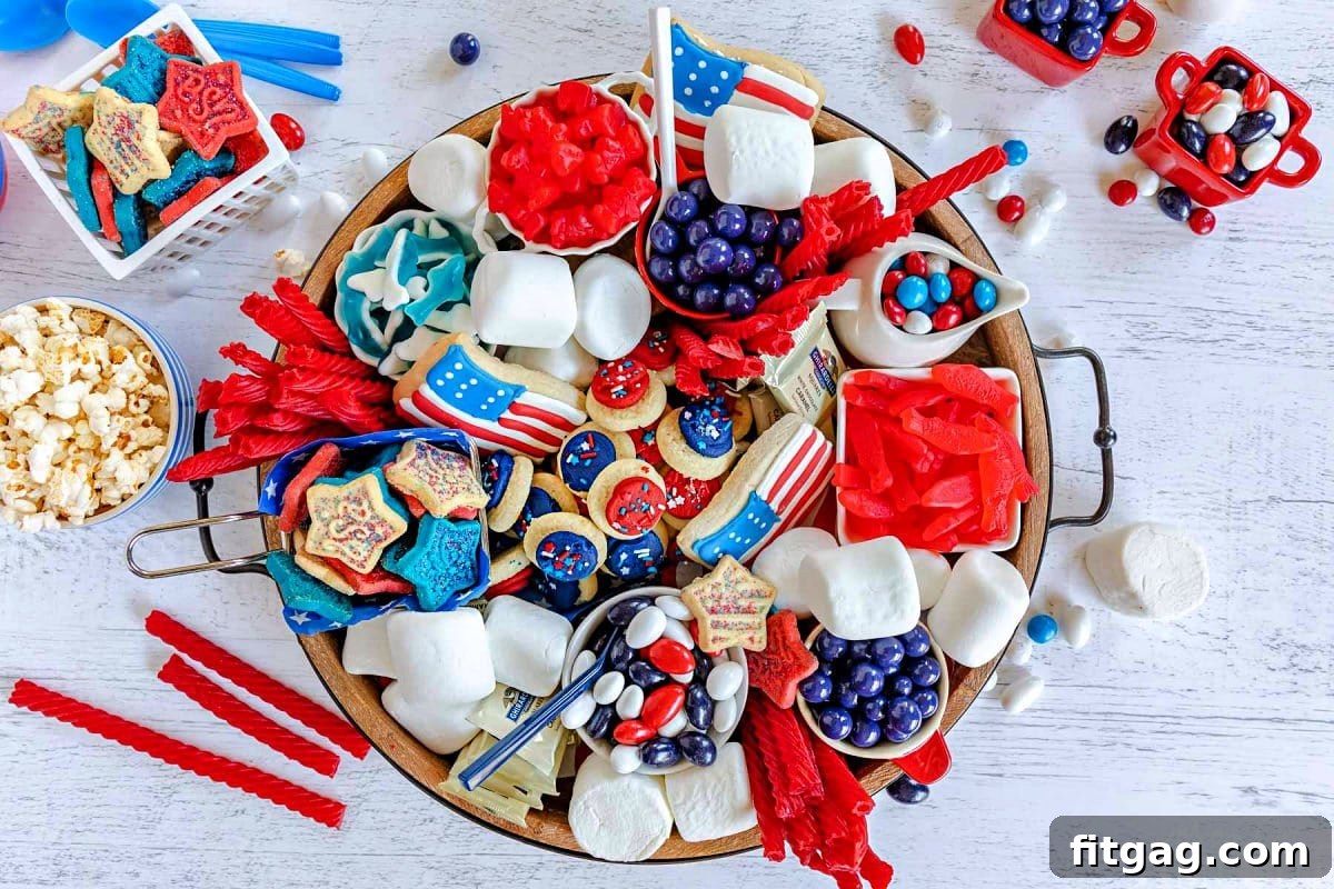 Stars and Stripes Grazing Board 9 A top-down view of a wooden charcuterie board overflowing with an assortment of red, white, and blue desserts, including various cookies, candies, and other colorful sweet treats, all perfectly arranged for a 4th of July celebration.