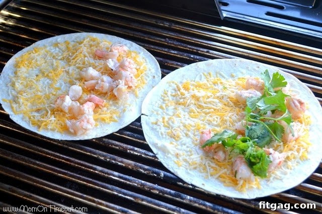 A folded shrimp quesadilla with golden grill marks resting on the grill